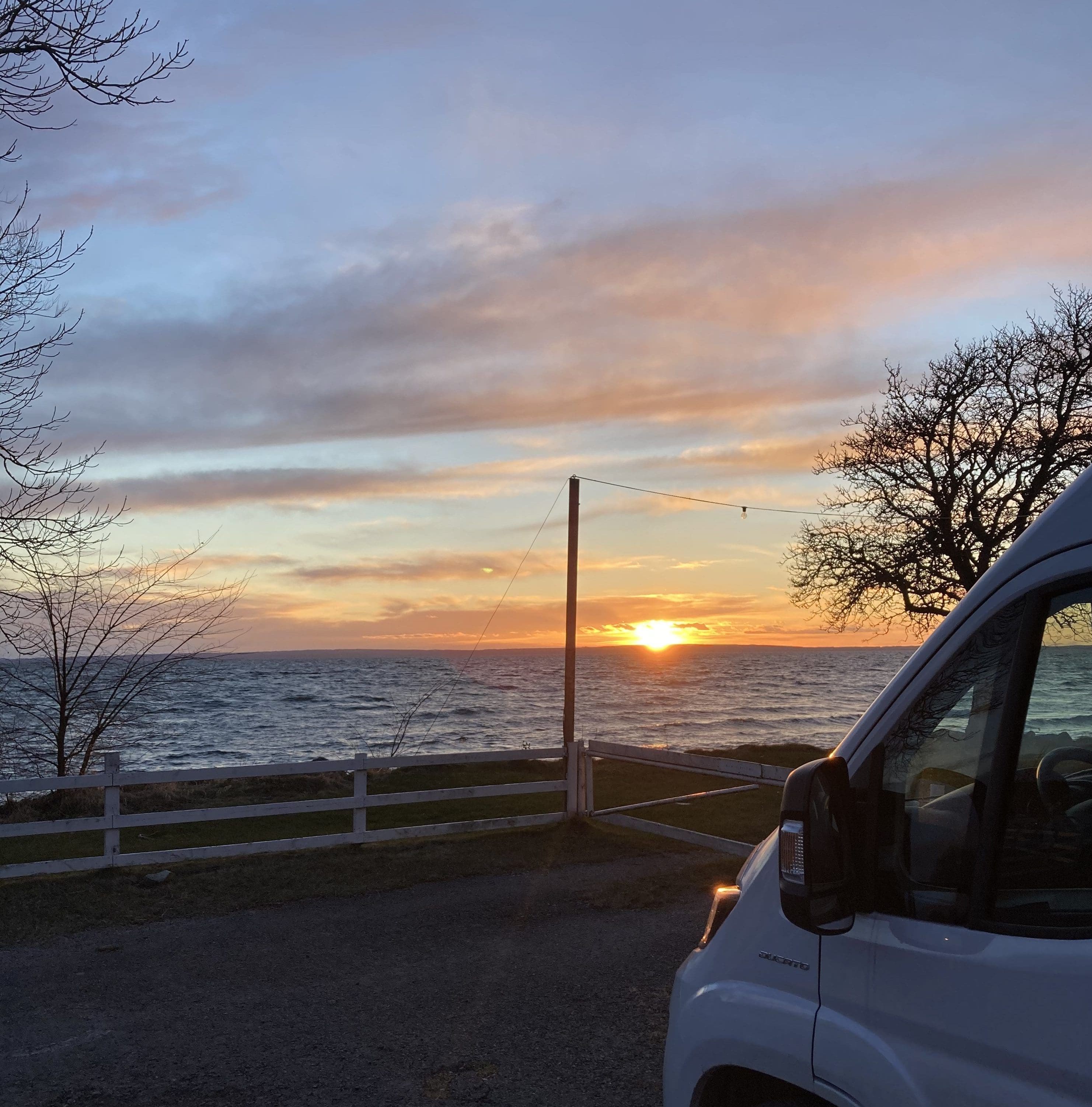 Wohnmobil bei Sonnenuntergang am Wasser