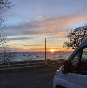 Wohnmobil bei Sonnenuntergang am Wasser